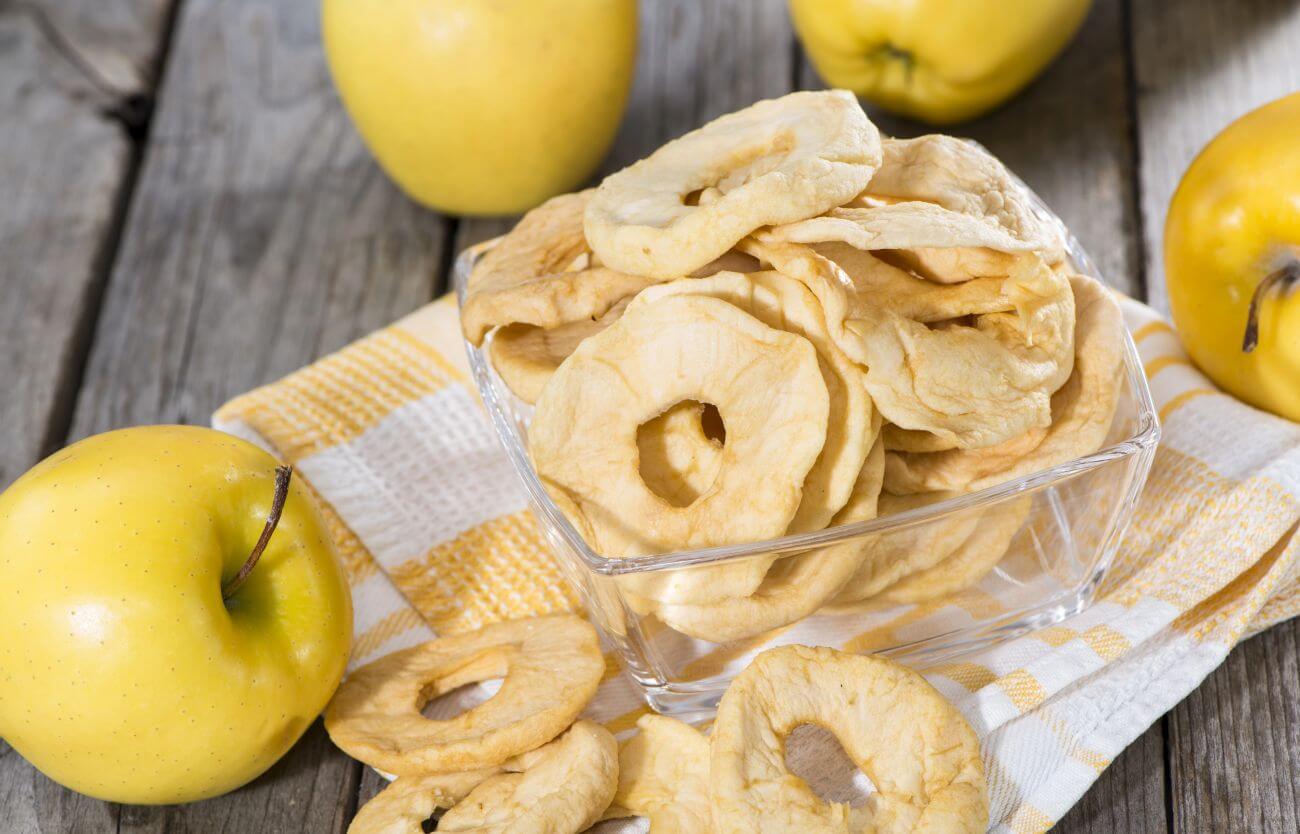 Suszone jabłka w otoczeniu świeżych jabłek